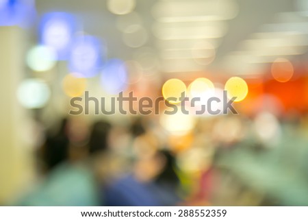 Blur photo of an airport terminal with unrecognizible passengers passing by with luggage. Blurred background for topics of travel and transportation.