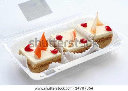 Three cakes in box on white background with shadow