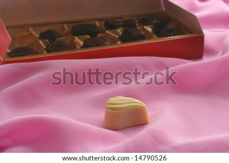 box of chocolate sweets and one of sweets, which extends separately on pink background
