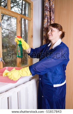 The woman in overalls washes a window