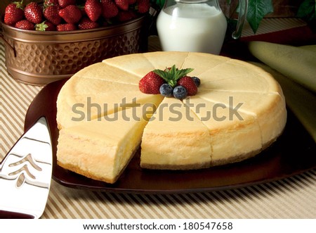 Cheesecake on Table with Strawberries and Milk in Service Setting