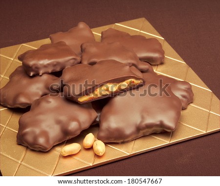 Chocolate Peanut Clusters on Gold Tile with Whole Peanuts and Caramel on Brown Service Setting; Chocolate Brittle: Peanut