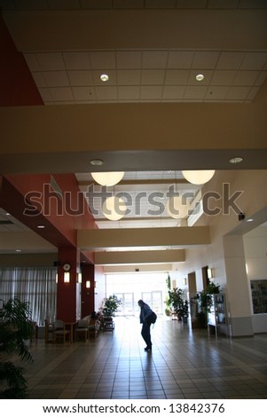 walking past a sunlit door at the library commons area
