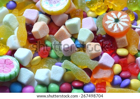 Candy, lollipop, colored smarties and gummy bears background