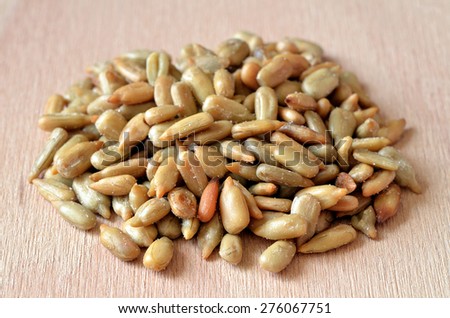 Close-up detail of heap of hulled sunflower seeds on wooden desk