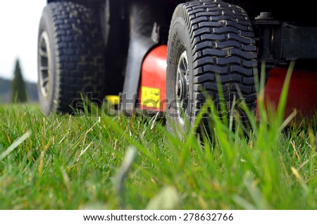 Close-up detail of wheel of garden mowers on green grass