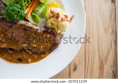 Beef steak in sauce on table