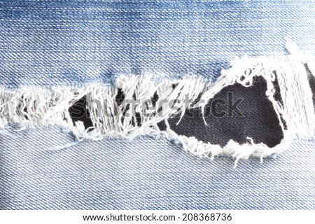 Blue denim jeans tear up present the old damaging fabic damaged.