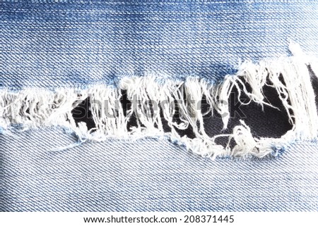 Blue denim jeans tear up present the old damaging fabric damaged detail of texture background.