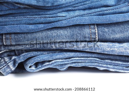 Blue denim jeans many pairs in bright color tone fold and stack up together.