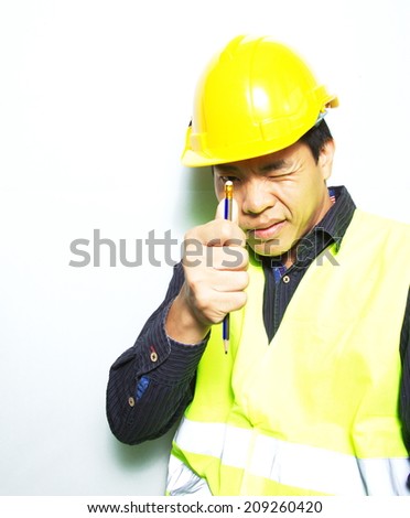 Asian young man wearing the yellow reflective safety jacket and safety helmet
