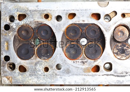 old and used vintage cylinder block made from aluminum alloy material present in the scene present the detail of valve of gasoline engine and damaged surface from carbon stain and rust stain.