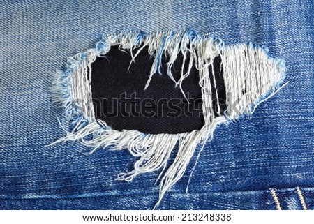 Blue denim jeans in dark color in the scene present the old denim look and old damaging fabric that shown detail of texture background.