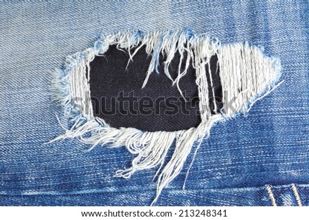 Blue denim jeans in bright color in the scene present the old denim look and old damaging fabric that shown detail of texture background.