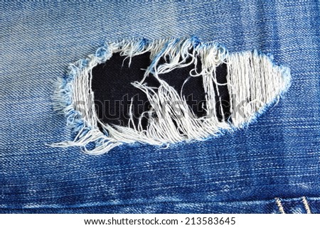 Blue denim jeans in dark color in the scene present the old denim look and old damaging fabric that shown detail of texture background.