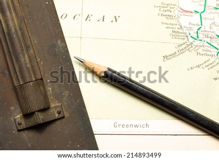 Old  and vintage paper map  with pencil and  old brass slide rule putting on it represent the detail of city name and destination.