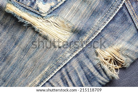 Blue denim jeans in bright color in the scene present the old denim look and old damaging fabric near the back pocket that shown detail of texture background.