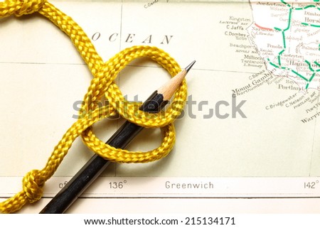 Gold color rope cable with simple knot put on old  and vintage paper map represent the detail of city name and destination.