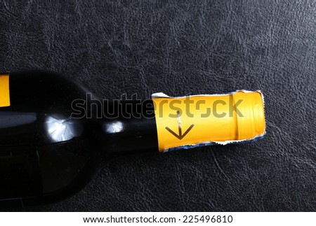Wine bottle in closing cap condition focus at the neck of the bottle to see the yellow color with golden arrow neck bottle label and tax stamp.