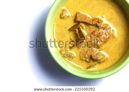 Pork yellow curry with turmeric powder in green bowl represent Thai cuisine and spicy curry with real southern Thai traditional food style