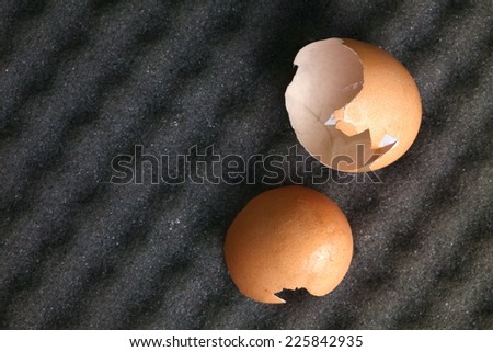 Broken egg put on the grey color sponge represent the broken egg shell still broke from a good protection