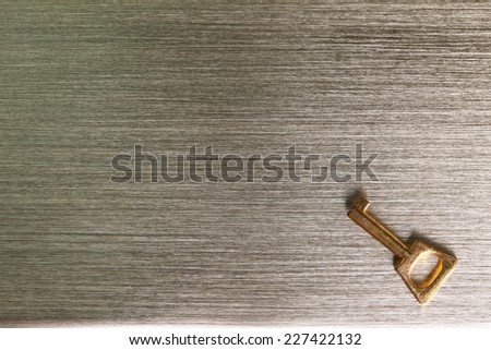A small golden chrome color key put on the chrome aluminum plate surface represent the abstract meaning.
