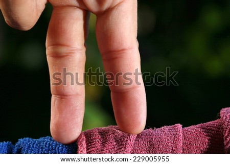 Man finger in action of standing on the clothes line in the scene represent the risk as an abstract idea.