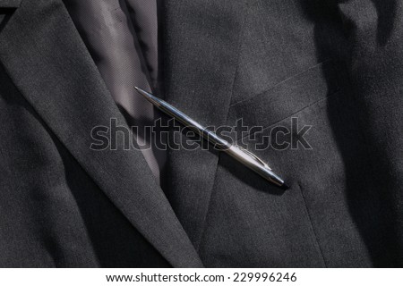 Grey color suit represent the formal uniform for businessman in the scene appear chrome ball pen strongly reflection shiny bright light also.