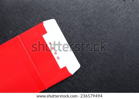 Red color of  paper envelop  put on the black color leather surface background  represent the Chinese new year and money giving traditional culture.