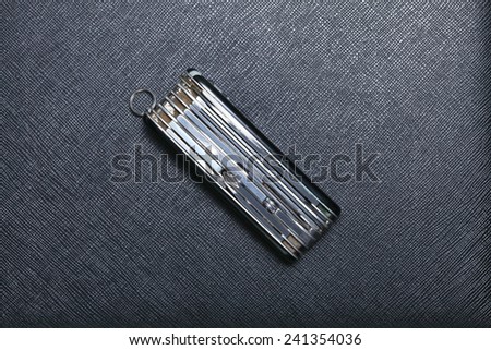 Old and classic stainless steel utility knife set put on black color leather surface background represent the knife equipment.