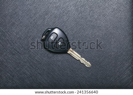 Remote control car key set put on black color leather surface background represent the car security system related equipment.