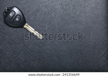 Remote control car key set put on black color leather surface background represent the car security system related equipment.