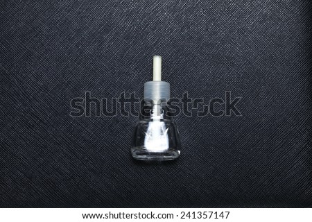 Old and empty car perfume bottle put on black color leather surface background represent the car deodorant related.