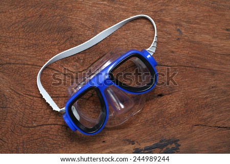 Diving mask goggles put on the hard  wood brown color surface background represent the skin diving equipment