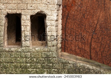 Old and vintage surface texture of sand stone pavilion wall and window architectural sculpture model with moss stain represent the texture and surface background.