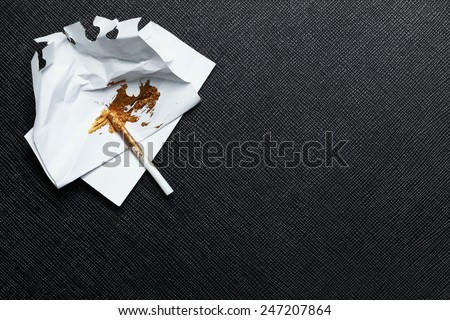 Gold color stain on the trash paper with plastic stirring rod put on the black color leather surface background represent the model making material.