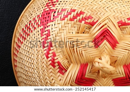 Weaving mesh cover use to cover food to protect it from insects in Thai traditional style put on the black color leather surface background represent Thailand traditional hygiene equipment related.