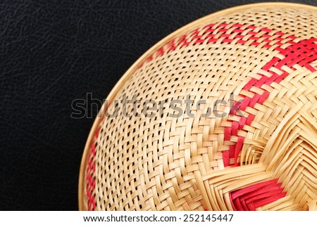 Weaving mesh cover use to cover food to protect it from insects in Thai traditional style put on the black color leather surface background represent Thailand traditional hygiene equipment related.