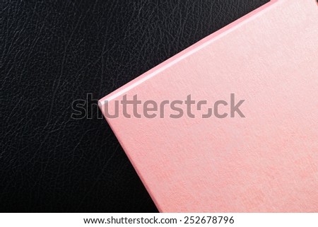 Pink color gift box put on the black color leather surface background represent the celebration material related.