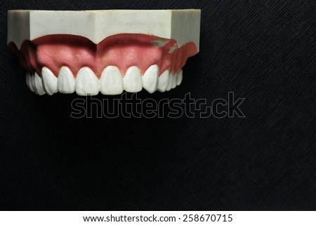 Teeth mock up model put on the black color leather background represent the dental care concept idea related.