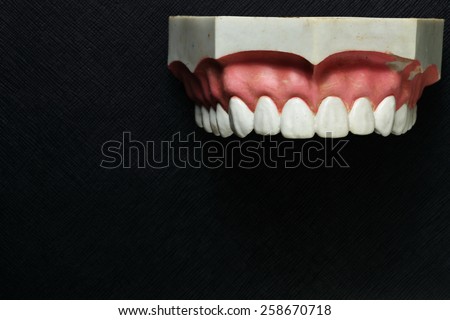 Teeth mock up model put on the black color leather background represent the dental care concept idea related.
