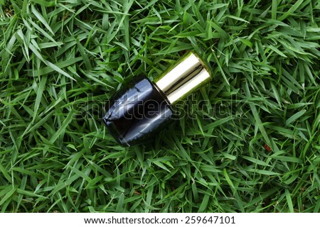 Nail color bottle for nail coloring put on grass background represent the manicure material related