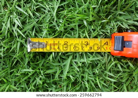 Cartridge meter red color put on grass background represent the measurement equipment related.