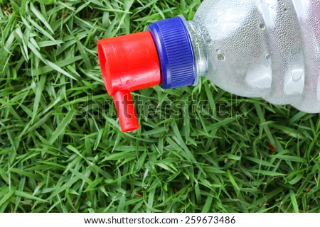 Distilled water for car battery bottle  in the scene show the head filling cap put on grass background represent the car battery necessary related concept idea.