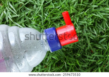 Distilled water for car battery bottle  in the scene show the head filling cap put on grass background represent the car battery necessary related concept idea.