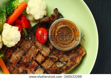 Pork chop steak and mixed vegetable ready to serve in the green plate represent the healthy food.