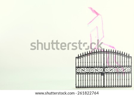 The plastic gate model in the scene appear the hand drawing house shape on clear acrylic surface represent the mortgage concept idea.
