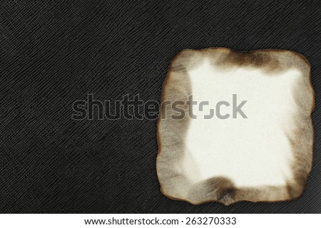Burned paper put on the black color leather background represent the retro style and vintage paper concept related idea.