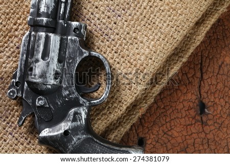 The artificial vintage plastic toy gun put on the brown color sack represent weapon concept related idea
