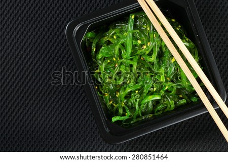 Japanese seaweed salad with bamboo chopsticks represent the Japanese food and cuisine concept related idea.